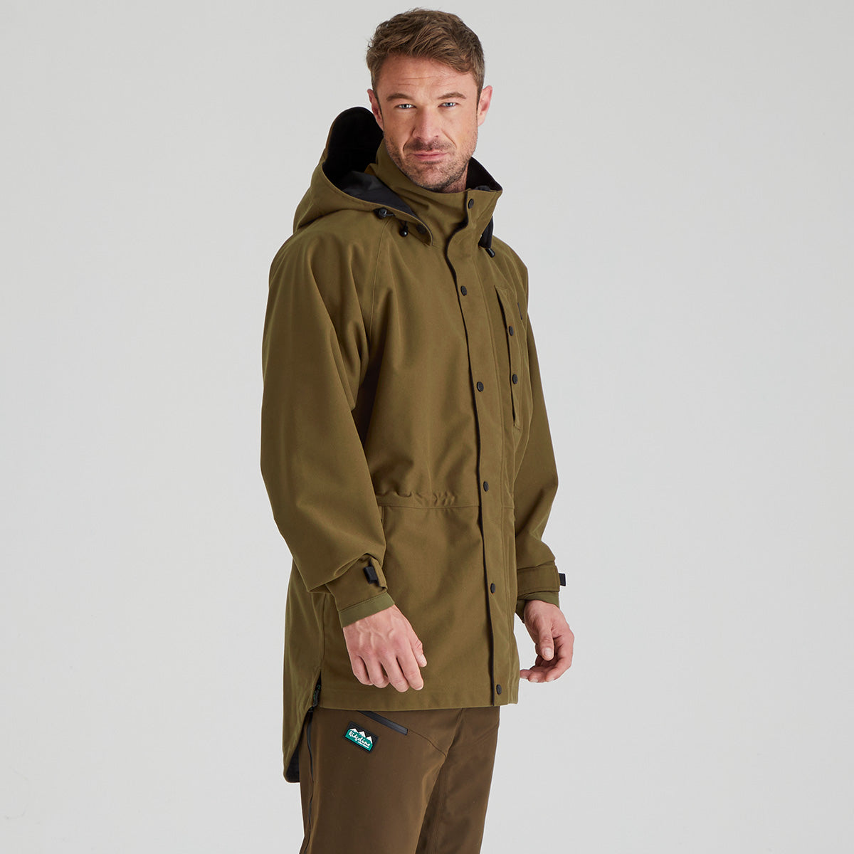 Man wearing a brown jacket on a light grey background