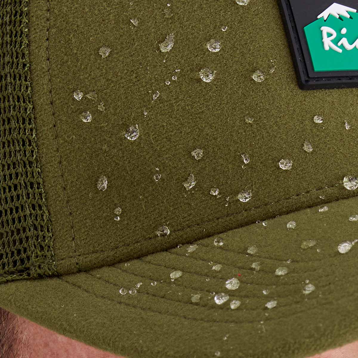 Green cap with water droplets and a visible brand logo on a blurred background