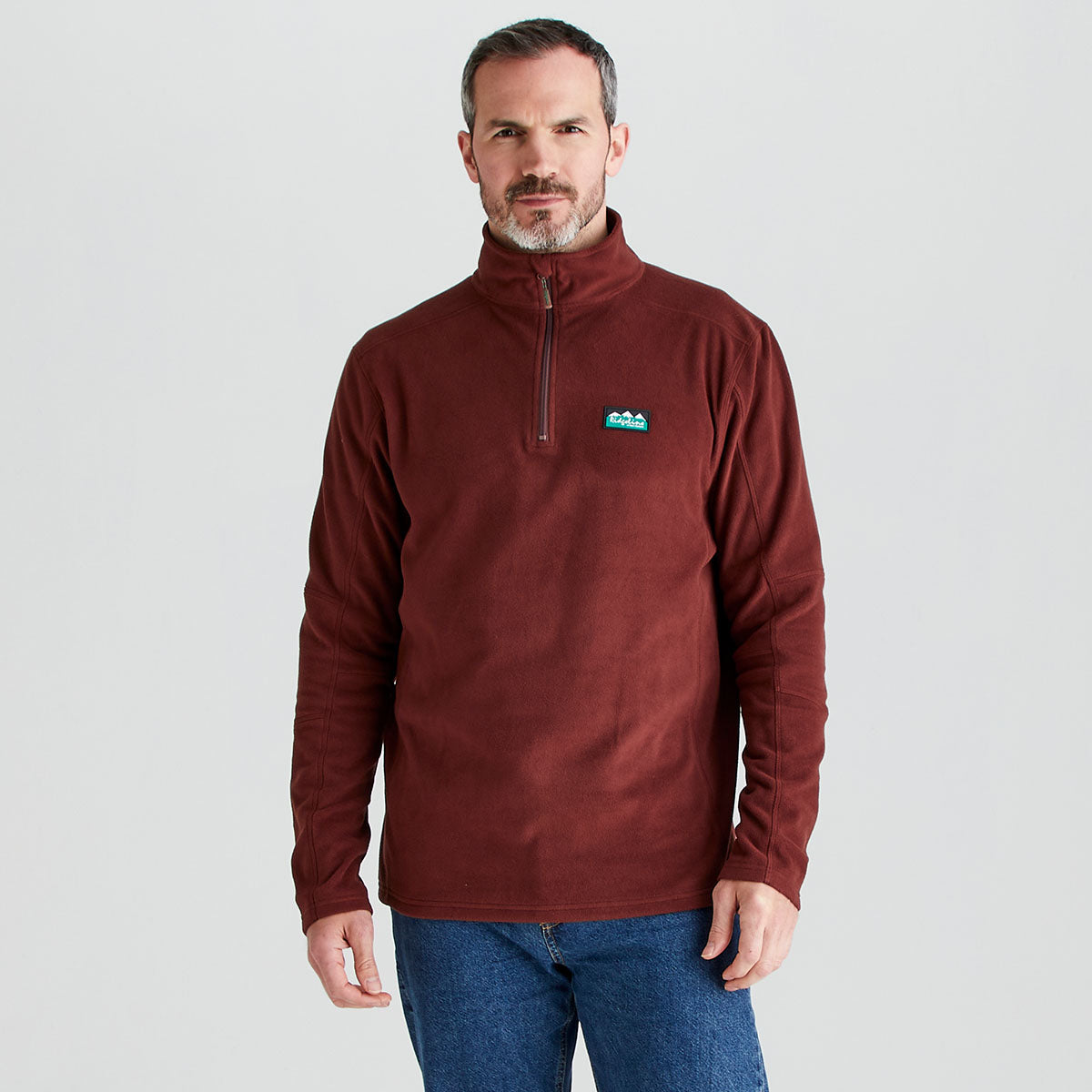 Man wearing a red ridgeline fleece quarter zip in a gray background