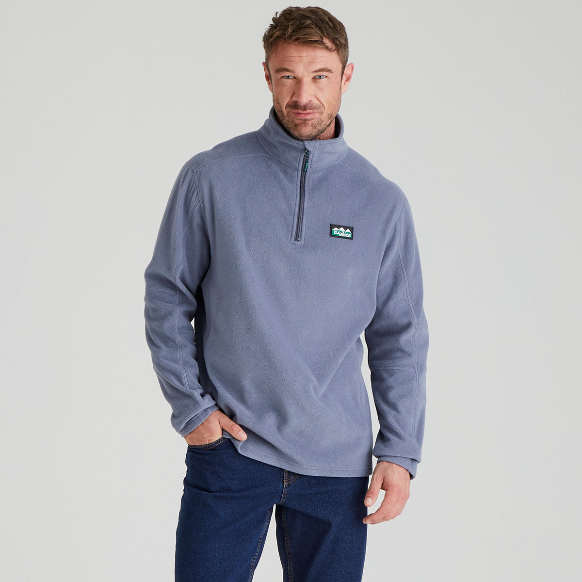 Man wearing a light blue fleece pullover with a Ridgeline Clothing logo on a grey background