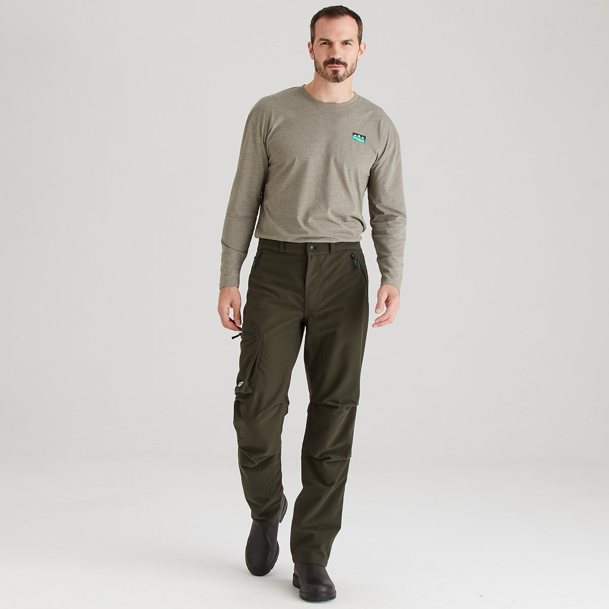 Man wearing a gray long-sleeve shirt and green cargo pants on a white background