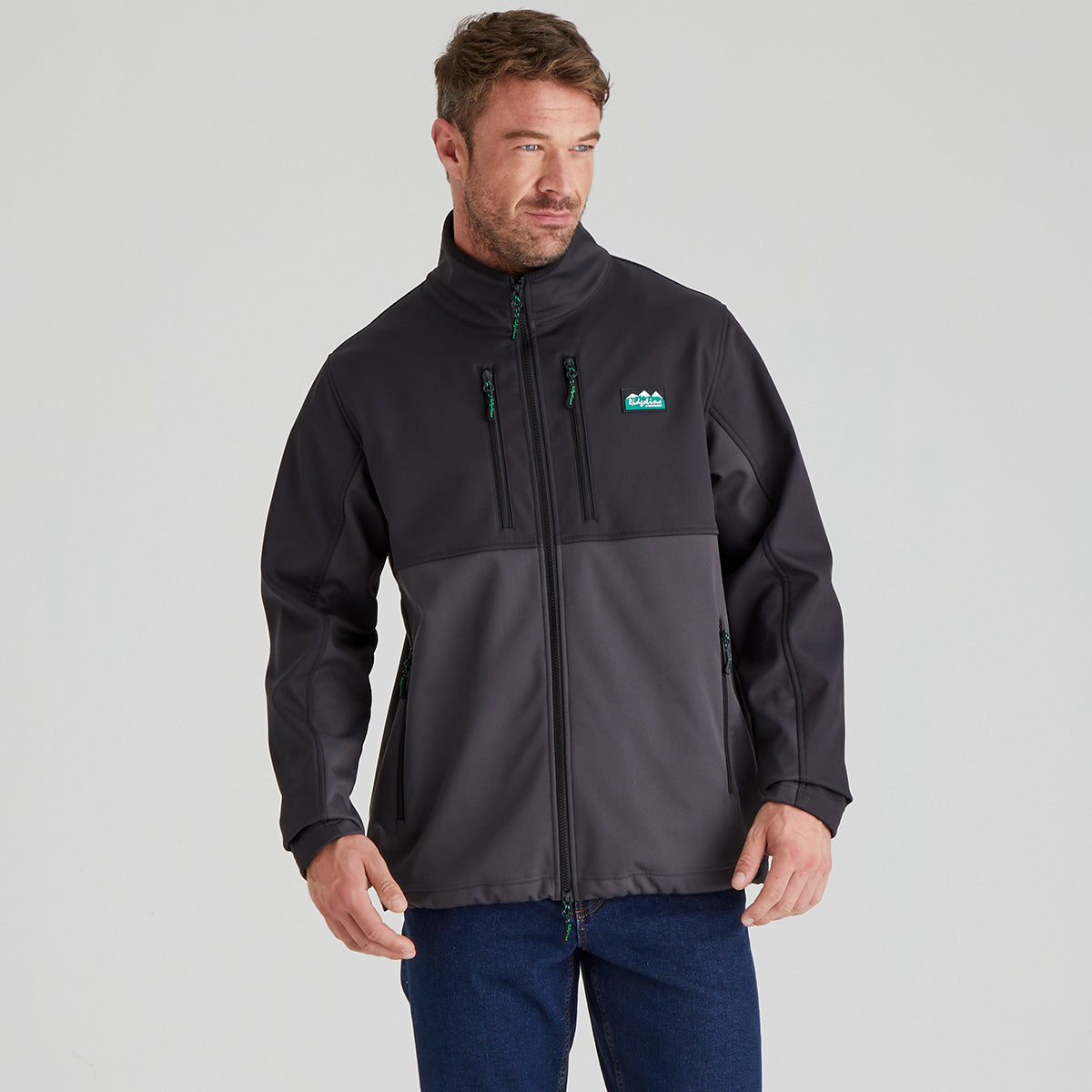 Man wearing a two-tone grey & black windproof jacket with a visible Ridgeline Clothing brand logo on a grey background