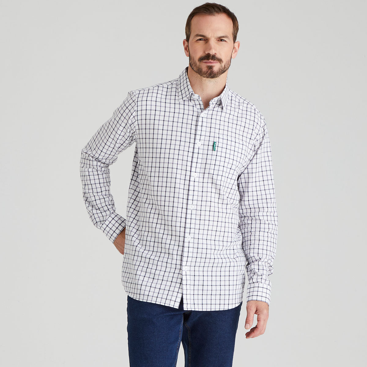 Man wearing a checkered shirt with a logo on a grey background