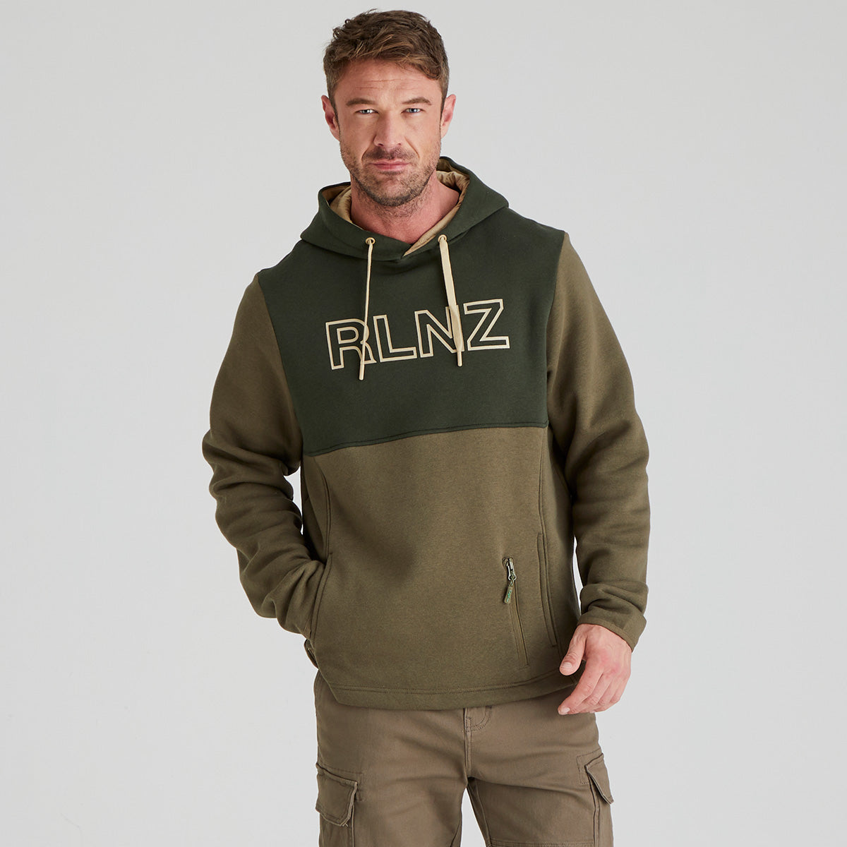 Man wearing a green and brown hoodie with 'RLNZ' logo on a gray background