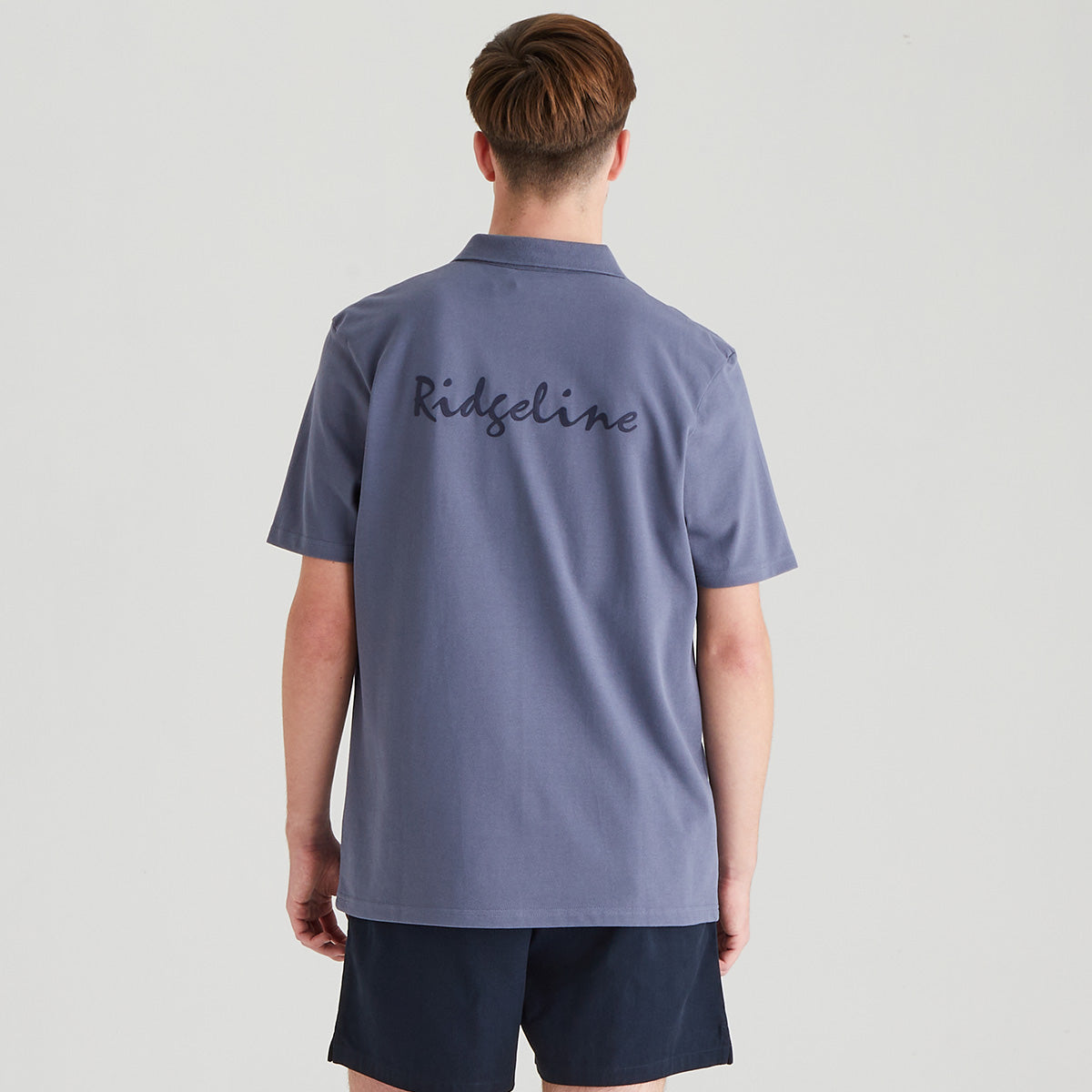 Person wearing a purple polo shirt with 'Ridgeline' branding on the back, standing against a plain background.