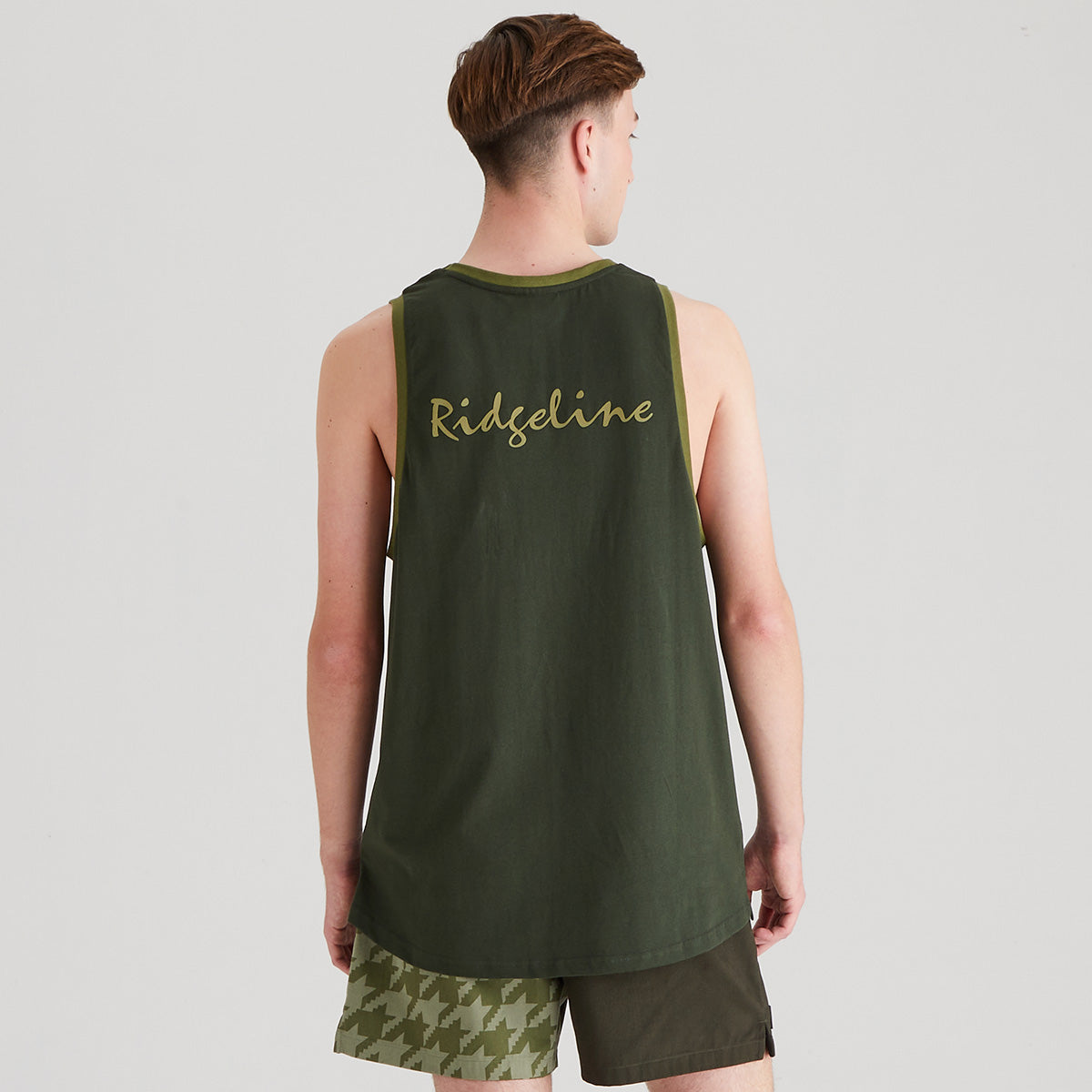 Person wearing a green tank top with 'Ridgeline' branding on the back, standing against a plain background.