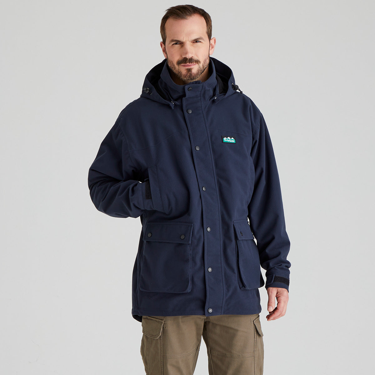 Man wearing a navy blue waterproof jacket with a Ridgeline Clothing brand logo on a grey background
