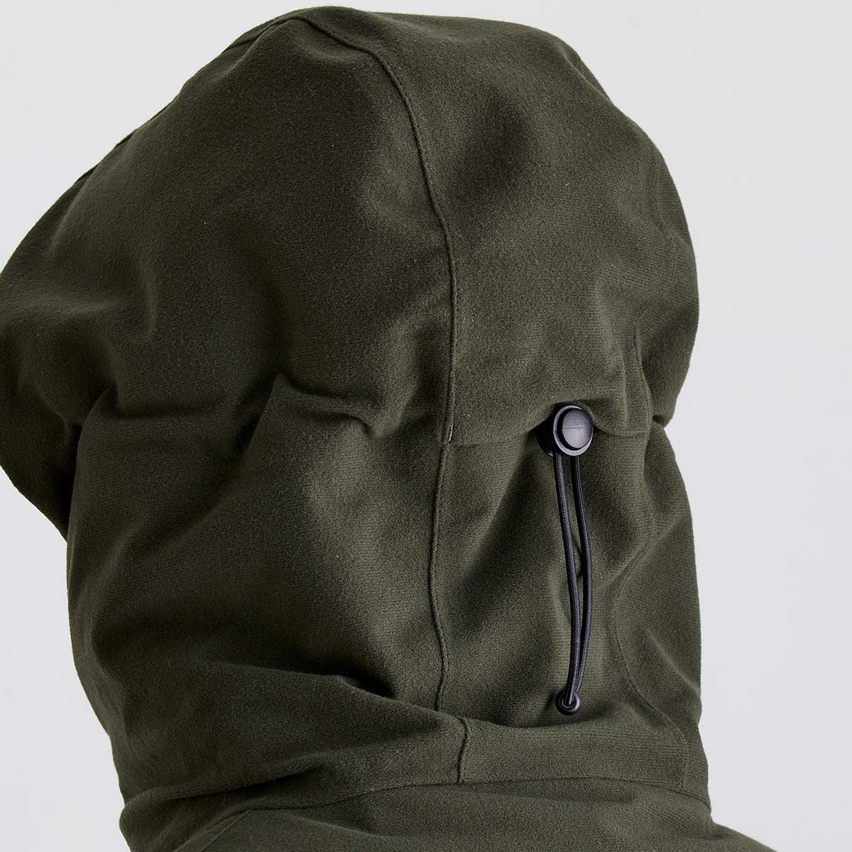 Close-up of a green jacket hood on a light gray background