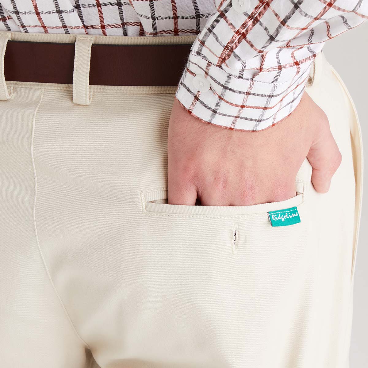 Beige pants with a visible brand label worn by a person.