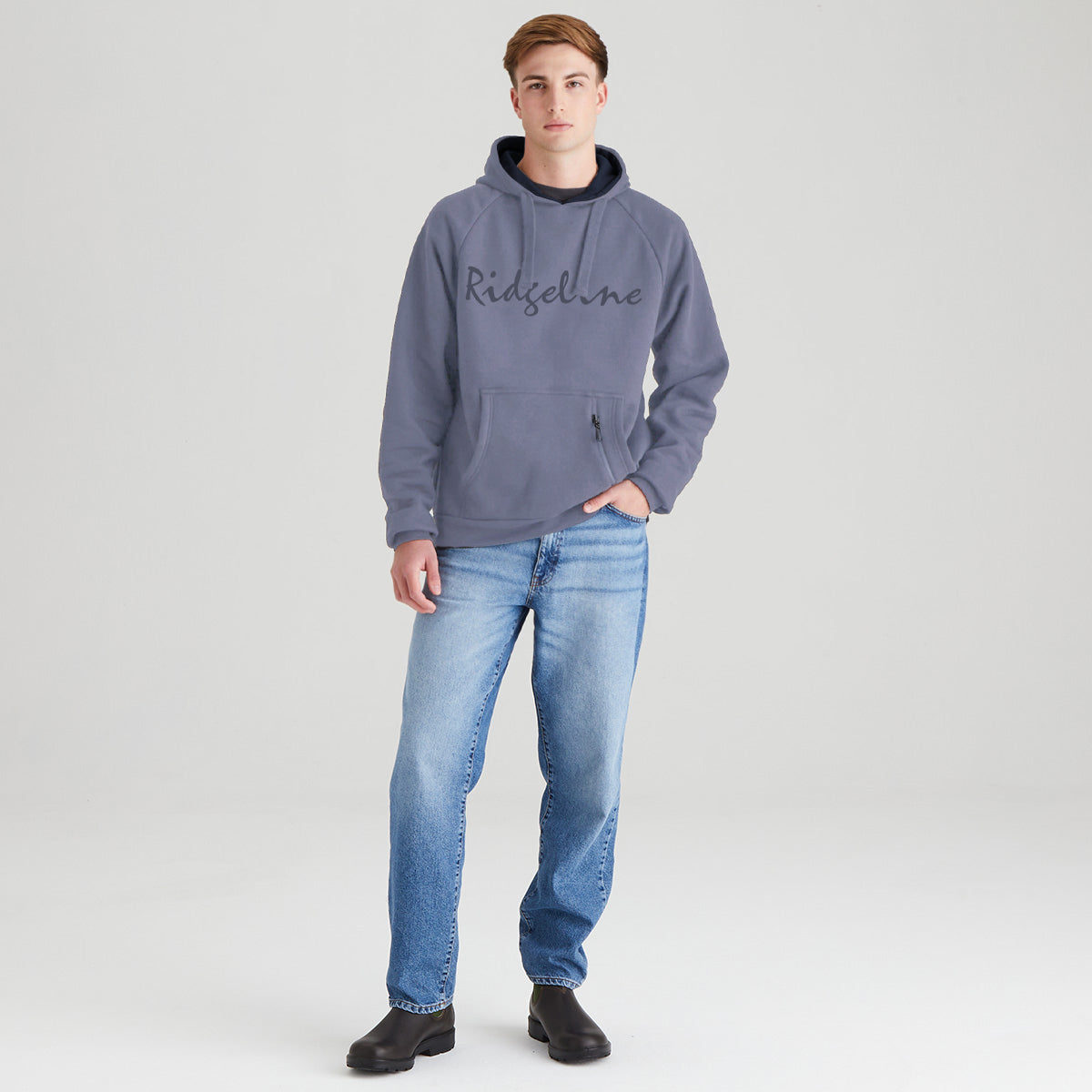 Person wearing a gray hoodie with 'Ridgeline' branding and blue jeans on a light gray background