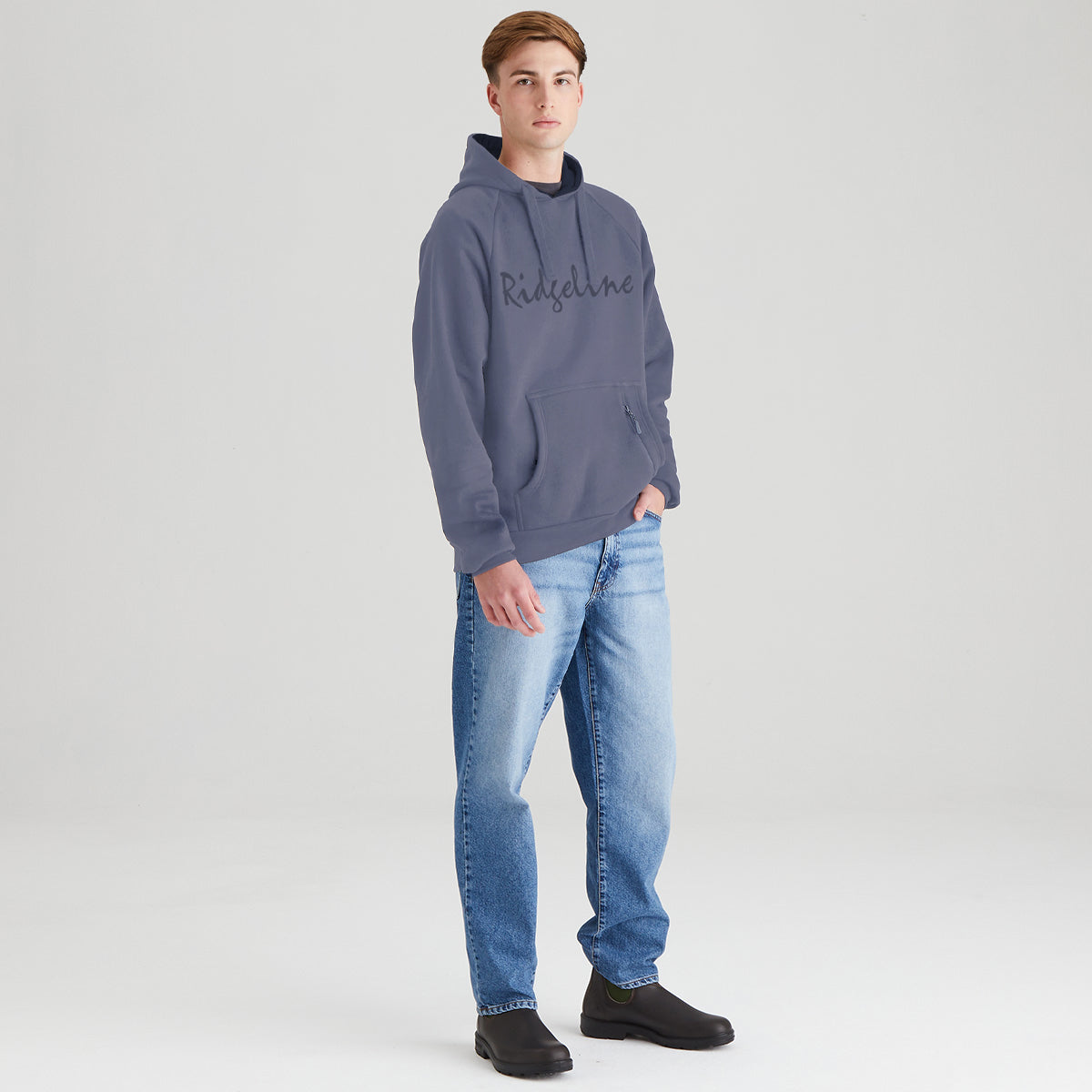 Person wearing a gray hoodie with 'Ridgeline' branding and blue jeans on a light gray background