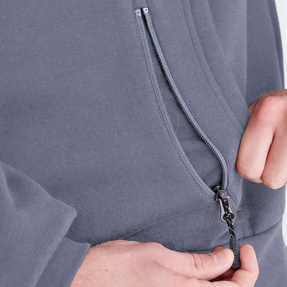 Close-up of a person zipping up a gray hoodie