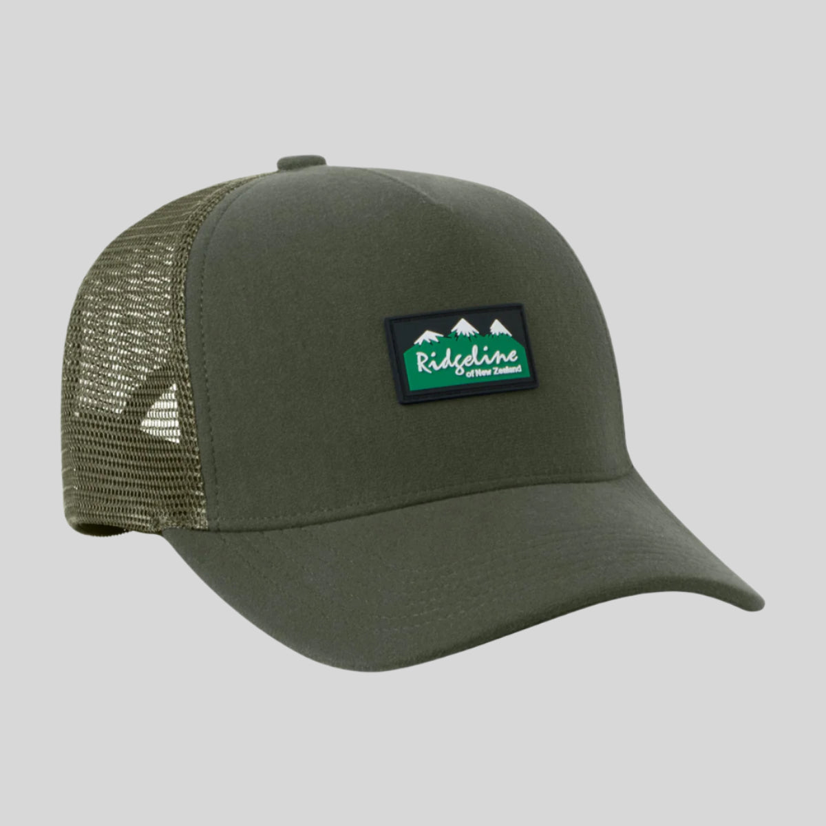 A green Monsoon trucker cap with breathable mesh panels and an adjustable back, featuring a waterproof peak.