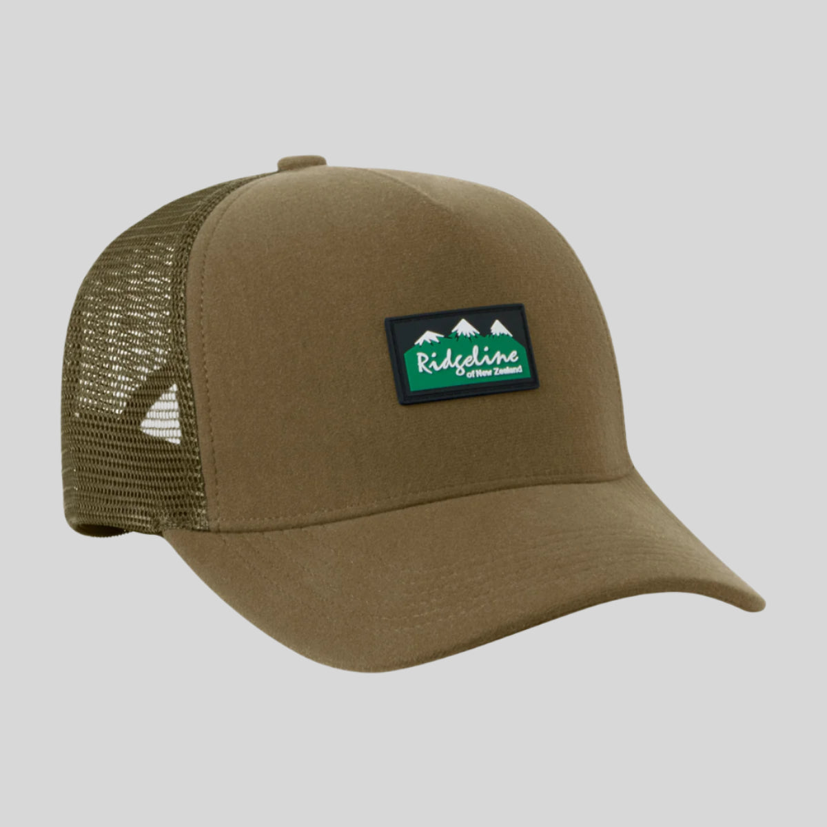 A brown Monsoon trucker cap with breathable mesh panels and an adjustable back, featuring a waterproof peak.