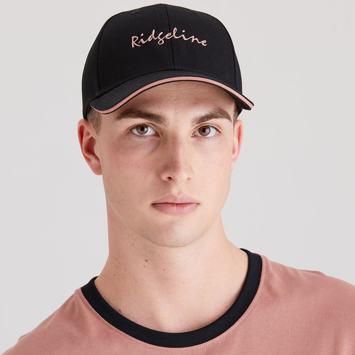 Man wearing a black cap with 'Ridgeline' branding on a light gray background