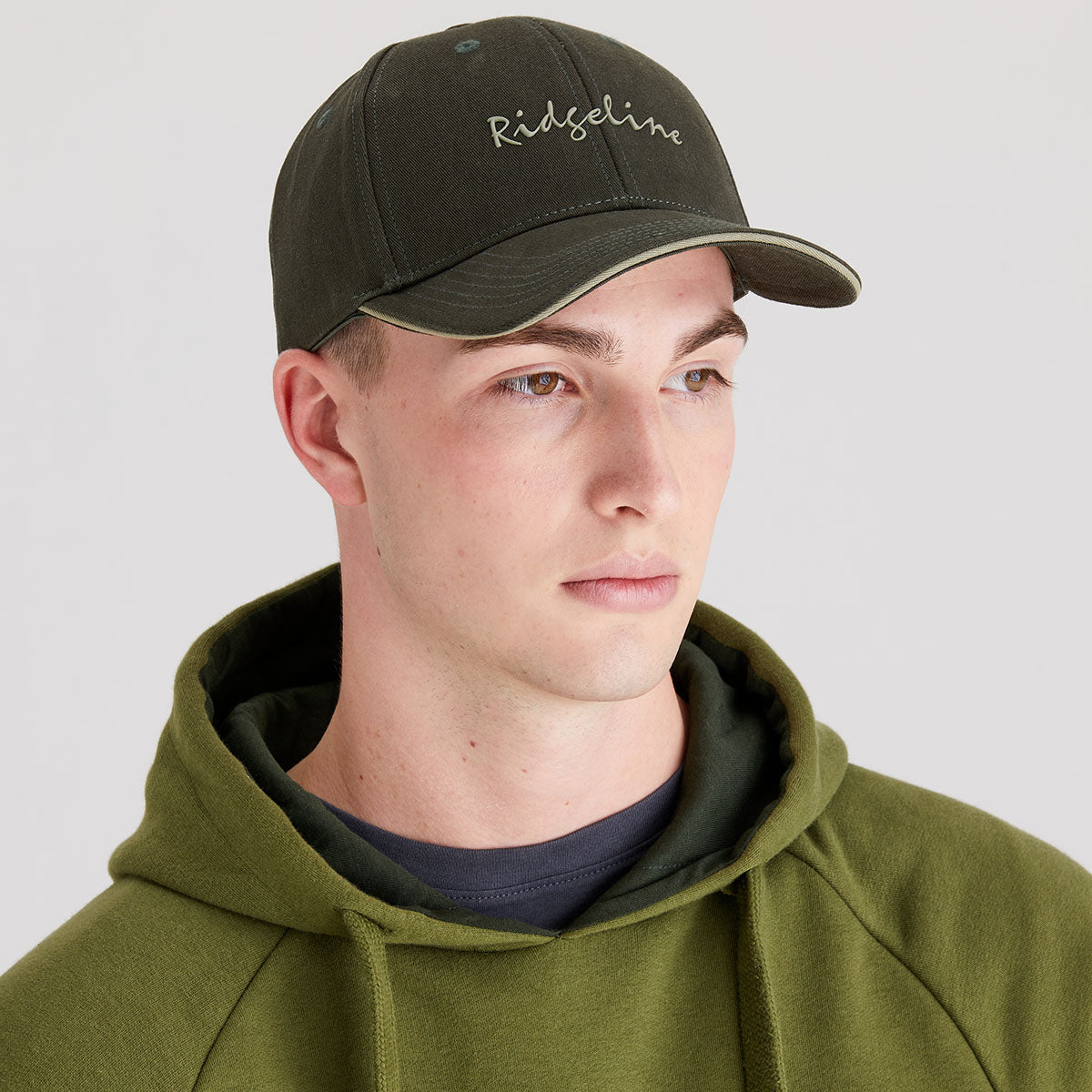 Man wearing a green cap with 'Ridgeline' branding on a plain background