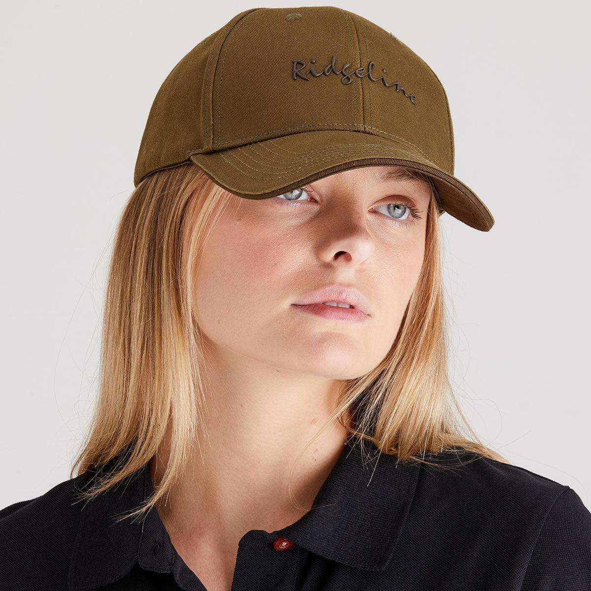 Person wearing a brown cap with 'Ridgeline' branding on a plain background