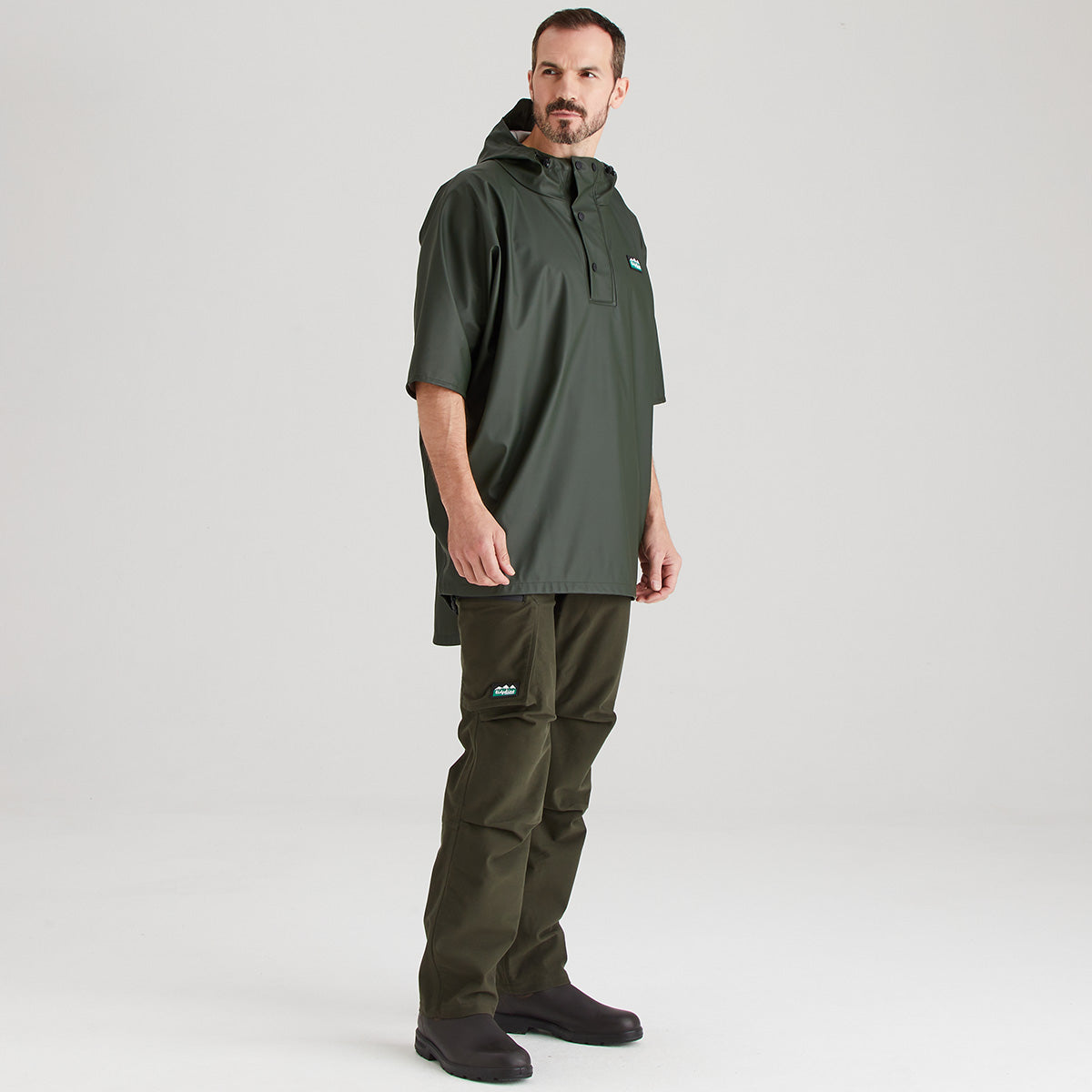 Man wearing a green raincoat and pants on a white background