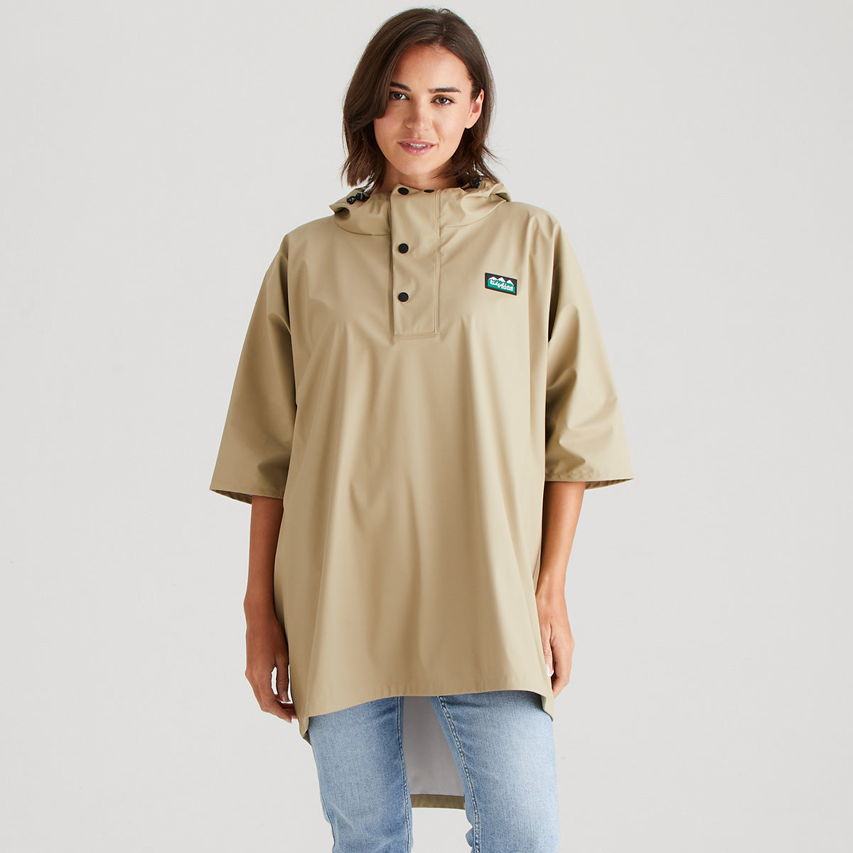 Person wearing a beige raincoat with a logo on a light gray background