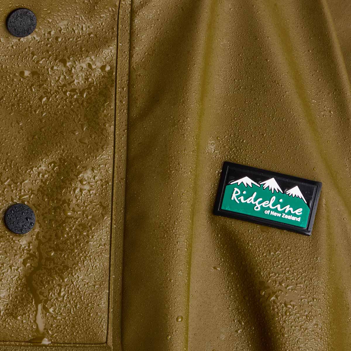 Close-up of a brown jacket with a 'Ridgeline' logo on a textured surface.