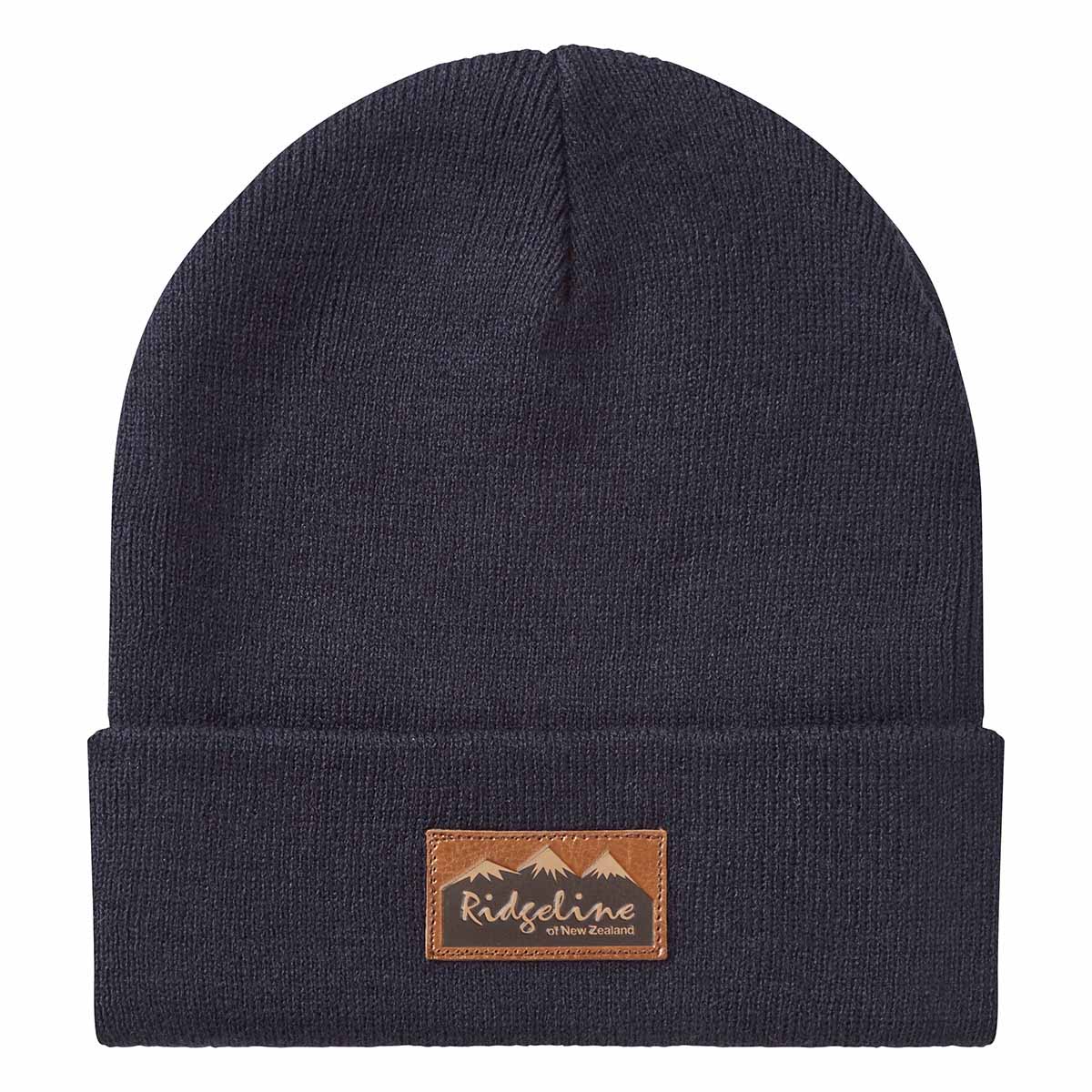 Front view of a navy blue ribbed knit beanie with a folded cuff, displayed against a light grey background. A brown faux-leather patch is centered on the cuff, featuring a mountain graphic and the text “Ridgeline of New Zealand.” The simple, classic design and stretch-knit construction are clearly visible, highlighting the beanie's snug fit and everyday outdoor style.
