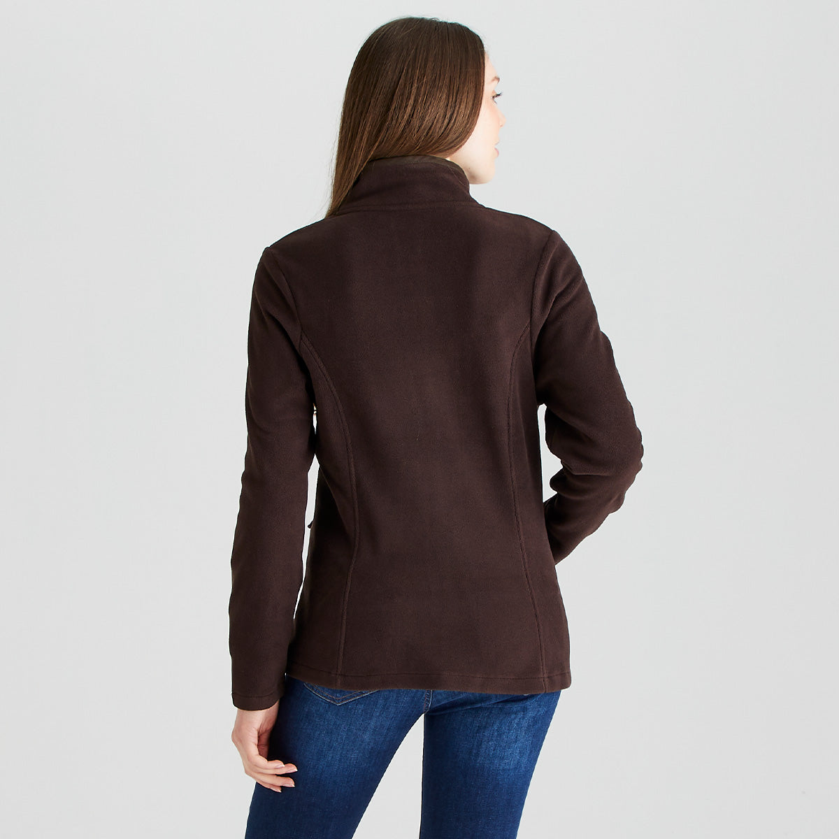 Rear view of a dark brown Ridgeline fleece jacket worn with blue jeans. The jacket features a high stand-up collar, a fitted silhouette, and long sleeves, with shaped seam detailing that enhances the streamlined fit. The soft fleece fabric is designed for warmth and comfort, making it suitable for outdoor and everyday wear. Photographed against a plain light-grey studio background, the image highlights the back fit and clean design of the Ridgeline fleece jacket.
