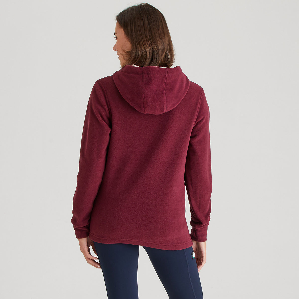 Person wearing a burgundy hoodie on a light gray background
