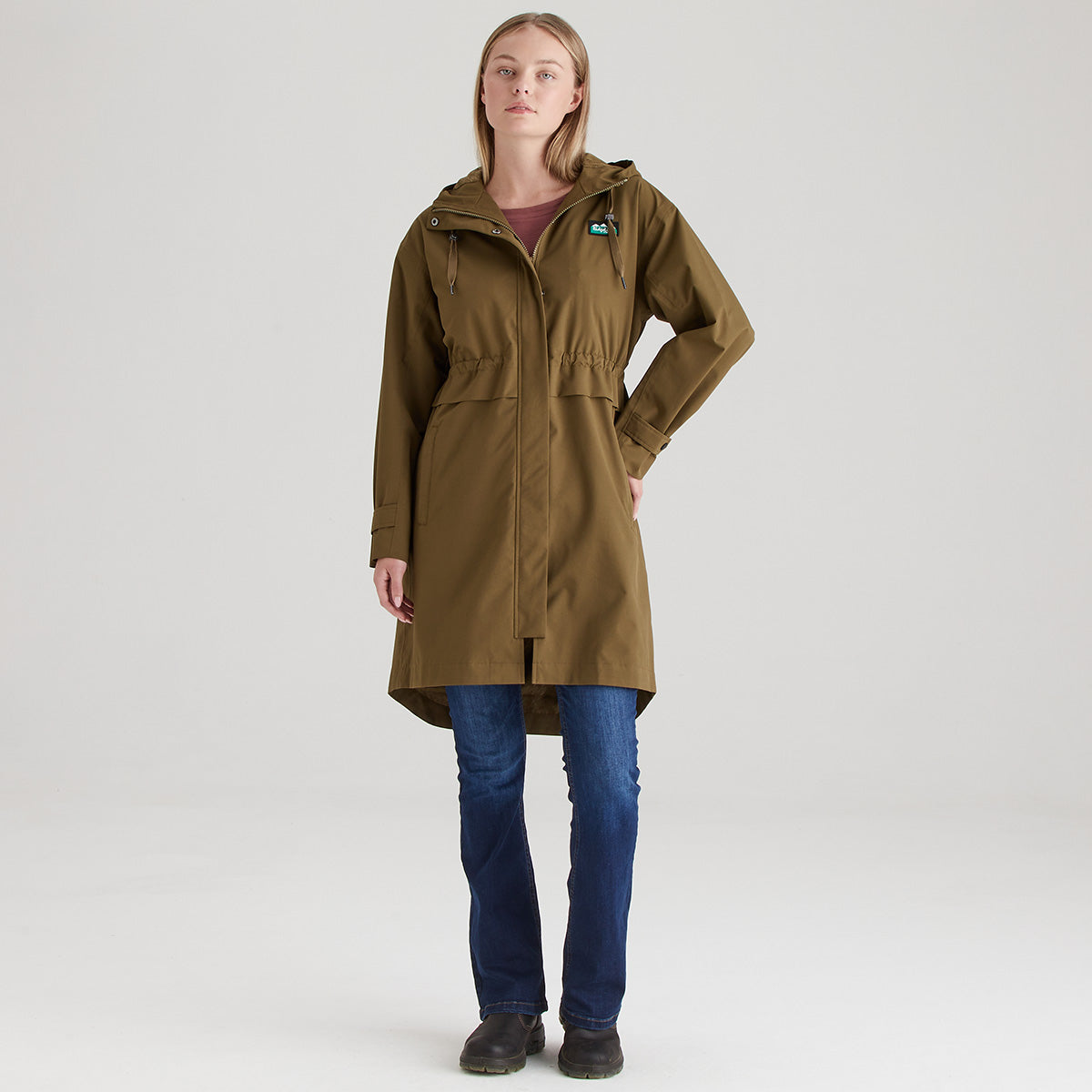 Woman wearing a brown raincoat on a white background