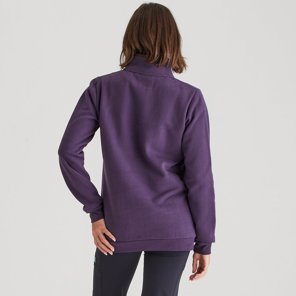 Person wearing a purple jacket on a light gray background