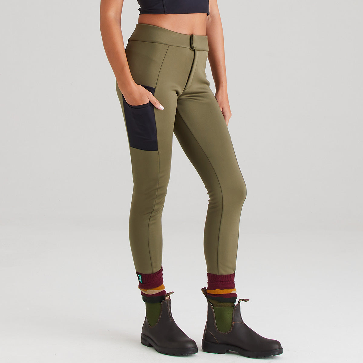 Person wearing green pants with black accents on a white background