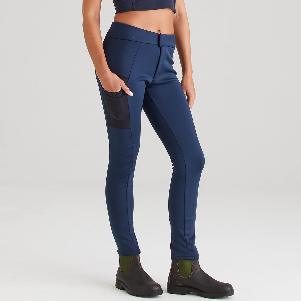 Person wearing navy blue riding pants on a light gray background