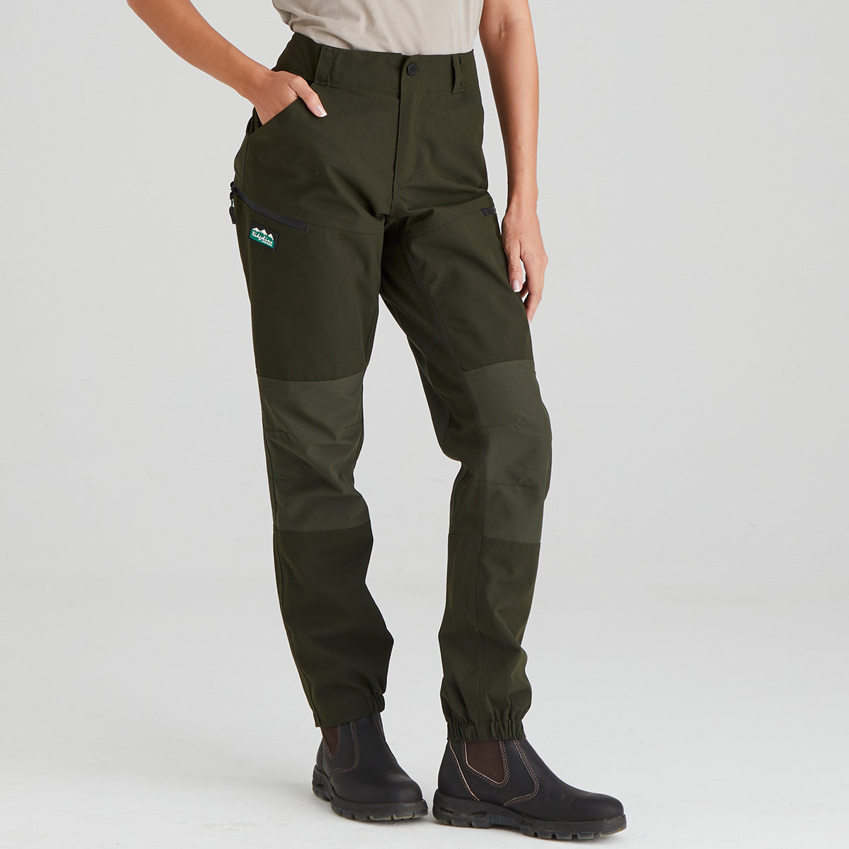 Green hiking pants with a ridgeline clothing brand logo on a light grey background