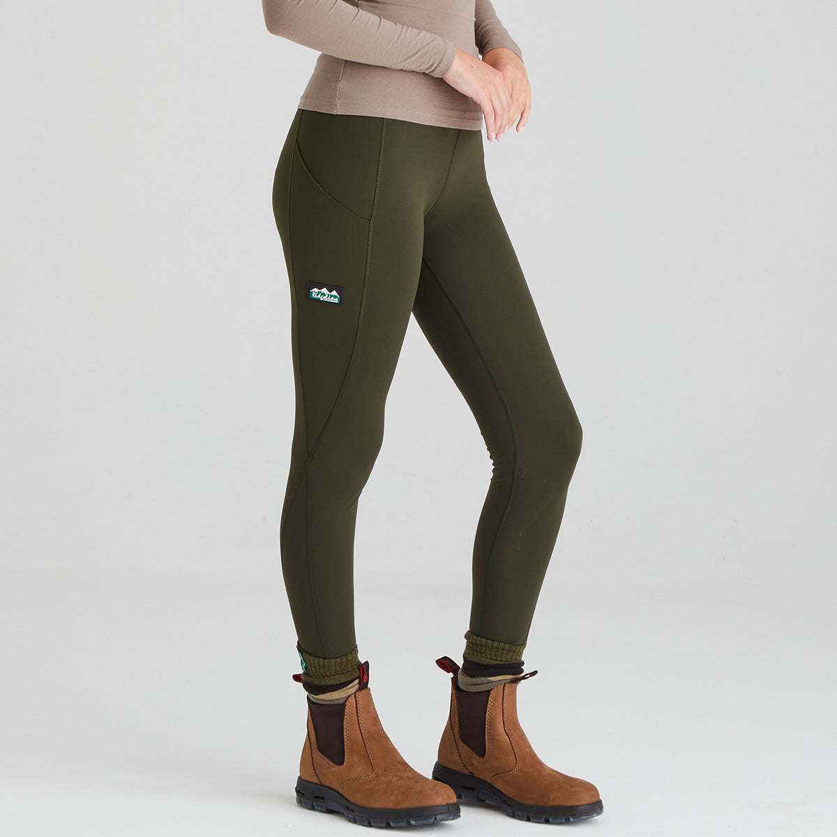 Person wearing green leggings with a visible Ridgeline Clothing brand logo on a white background
