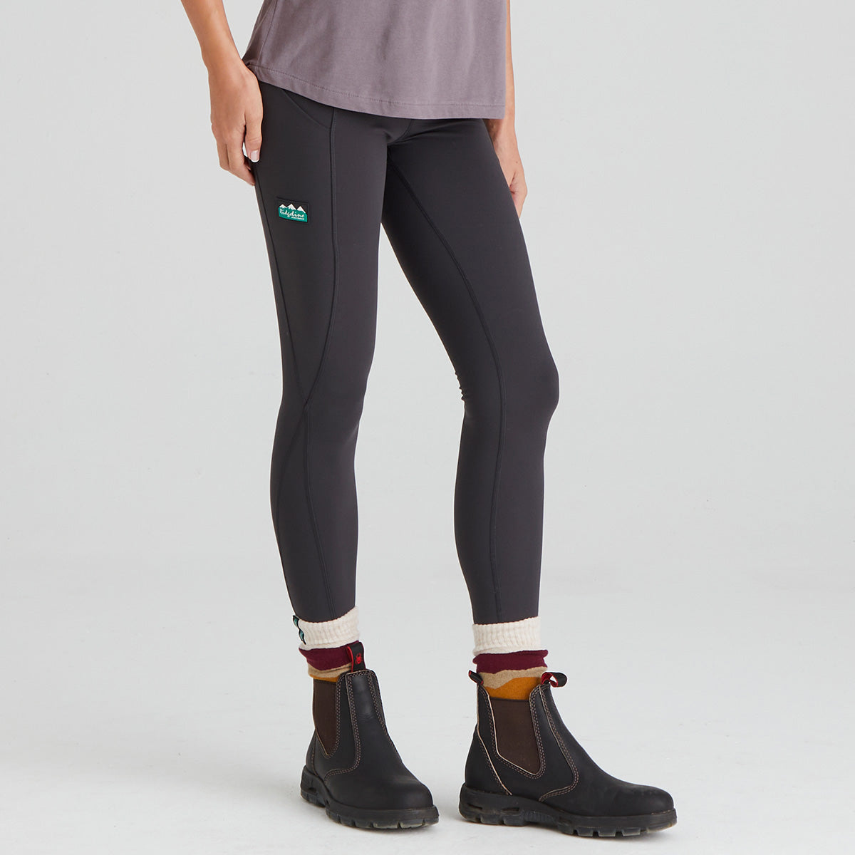Person wearing black leggings with a visible Ridgeline Clothing brand logo on a light grey background