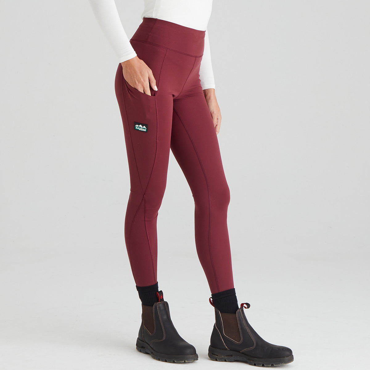 Maroon leggings worn by a person on a light grey background