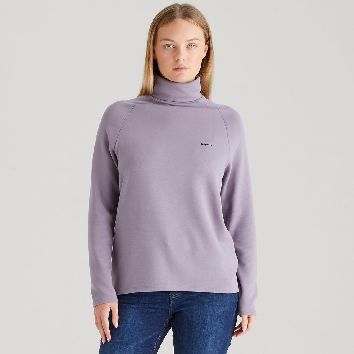 Woman wearing a light purple turtleneck sweater on a plain background
