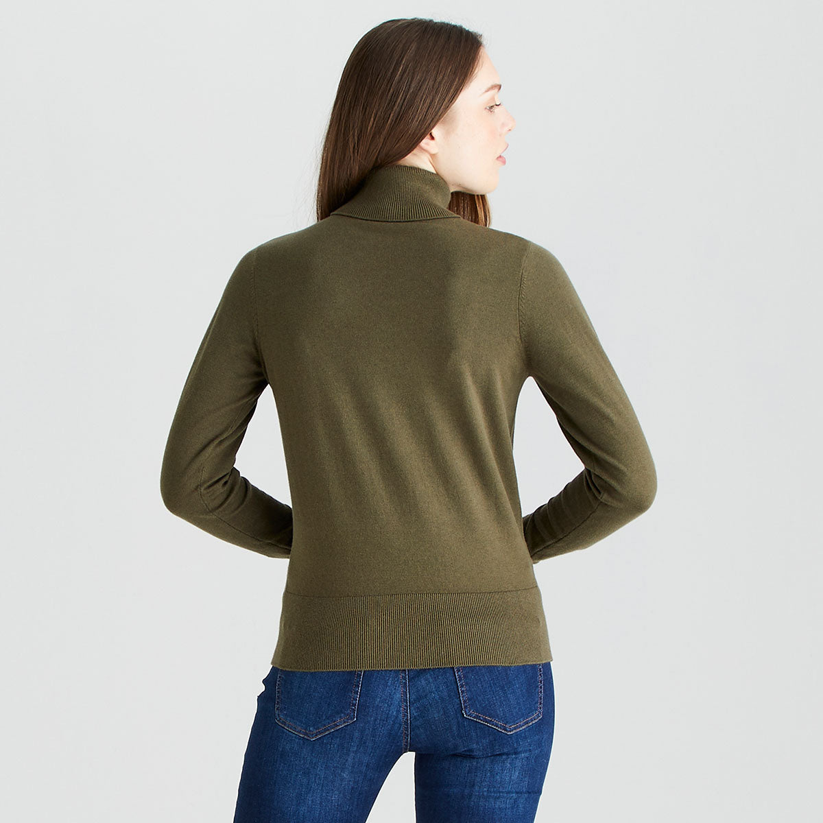 Rear view of a model wearing a Ridgeline knitted roll neck pullover in olive green. The fine-knit jumper features a high roll-neck collar, long sleeves, and a ribbed hem for a comfortable regular fit. Shown with blue jeans against a light grey studio background.
