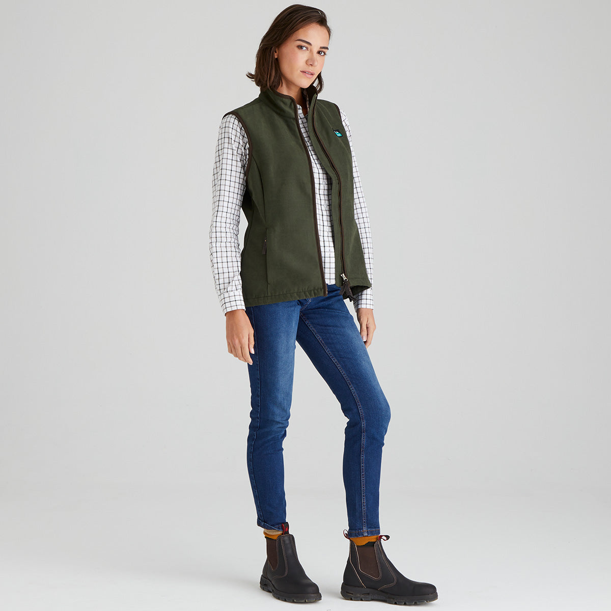 Woman wearing green moleskin gilet with a checked shirt