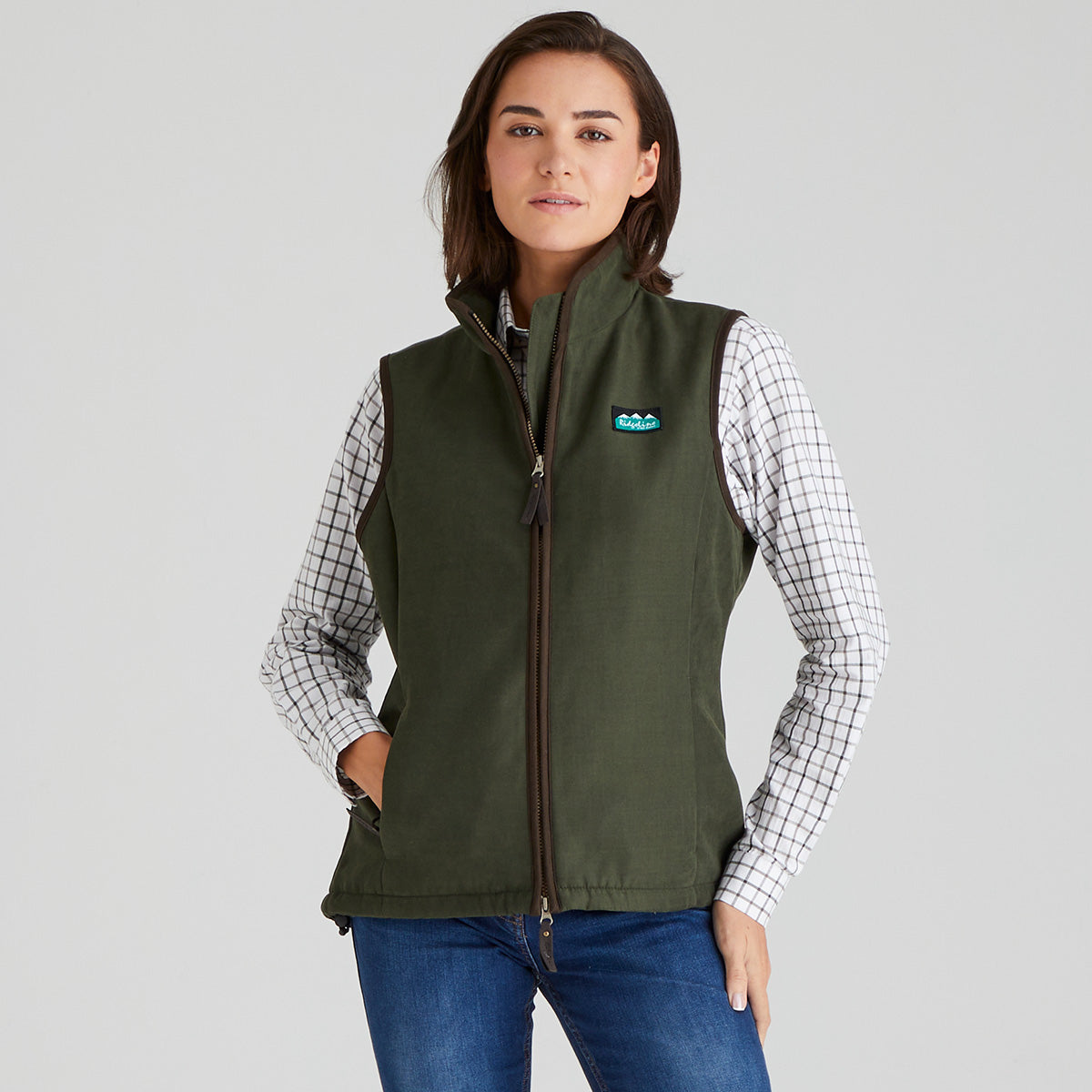 Woman wearing green moleskin gilet with a checked shirt