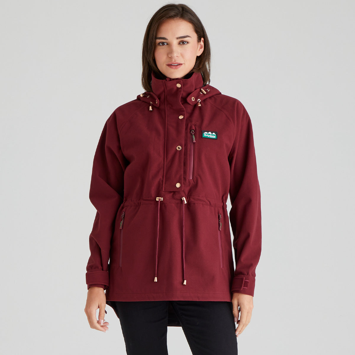 Maroon raincoat with brand logo worn by a model on a grey background