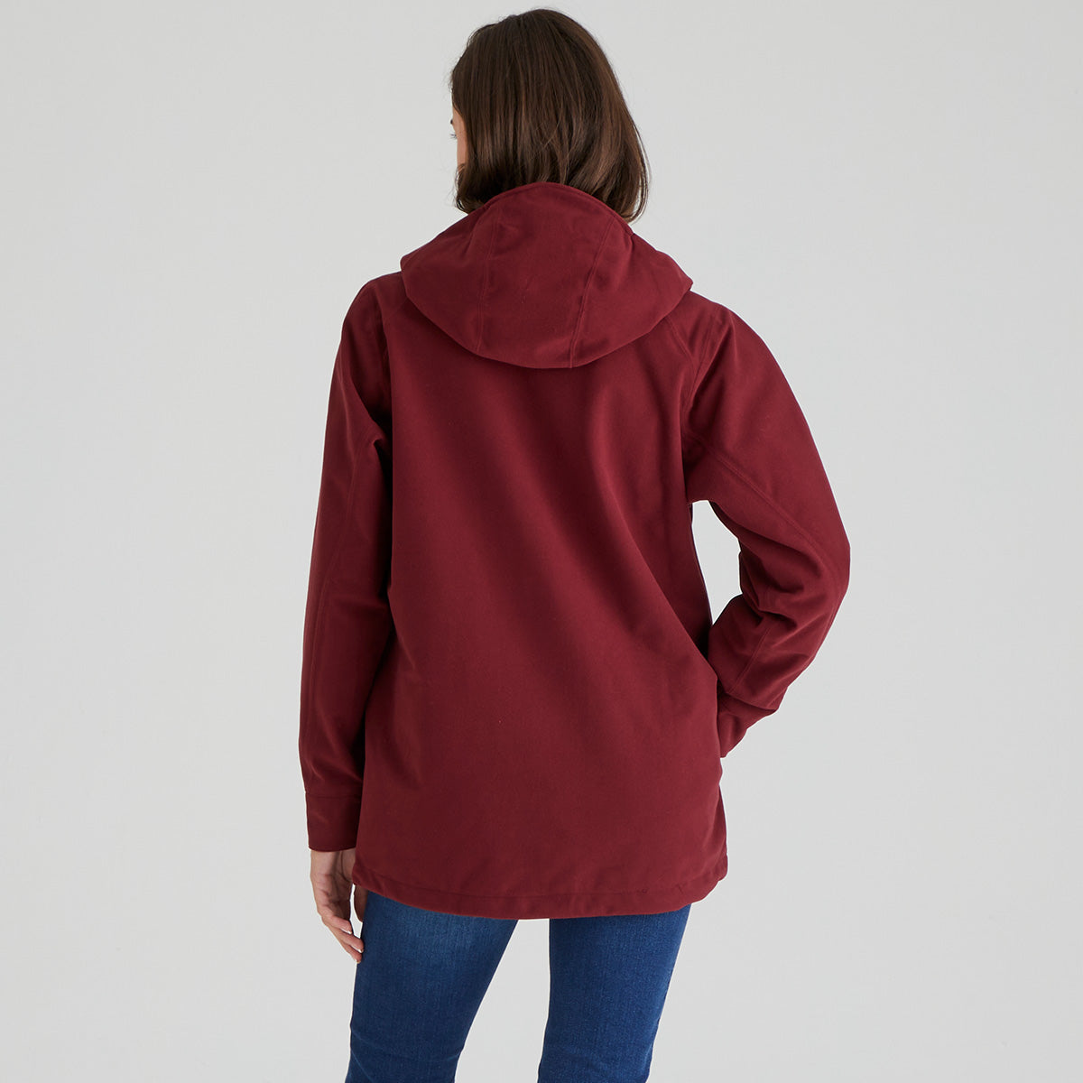 Person wearing a maroon jacket on a plain background