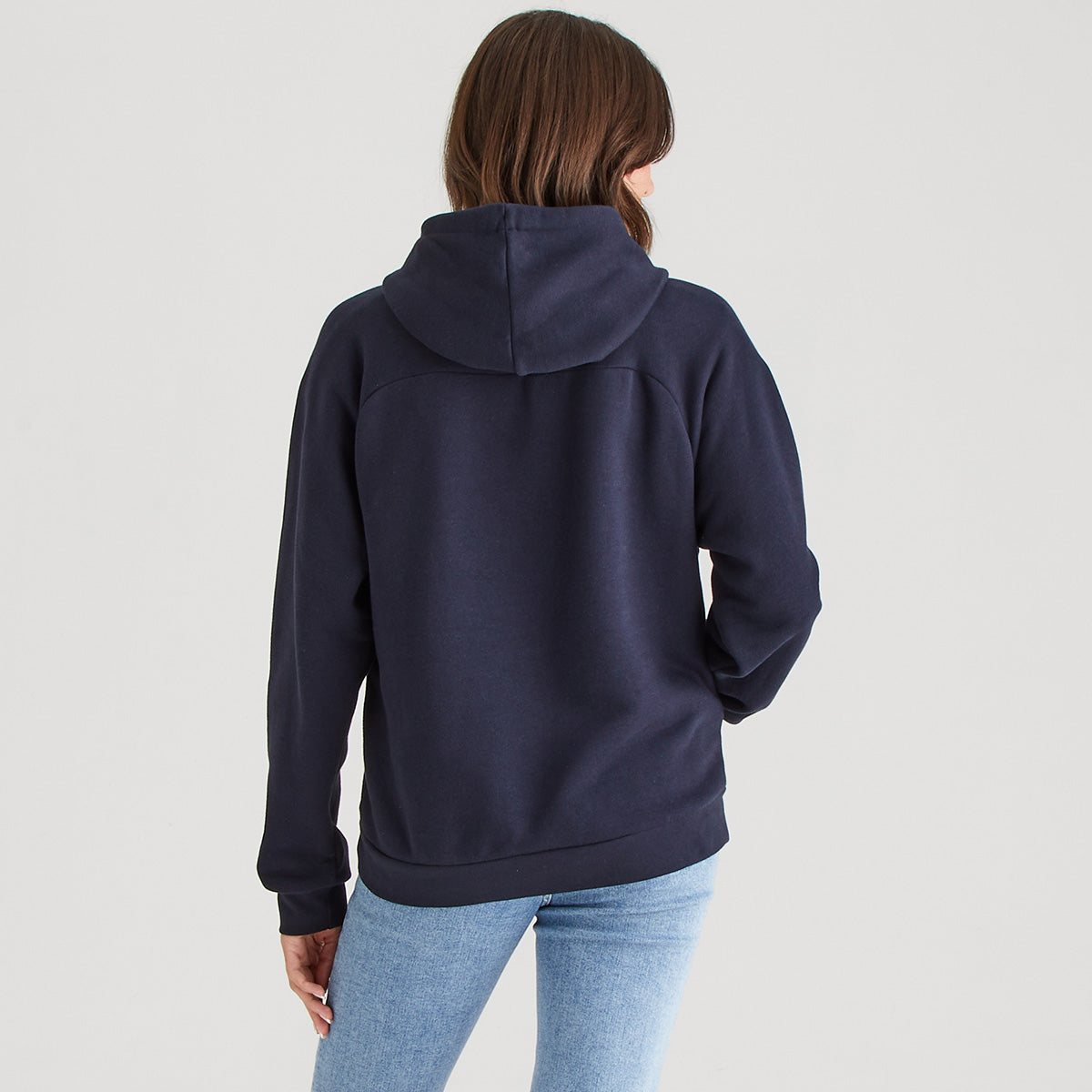 Person wearing a navy blue hoodie on a light gray background