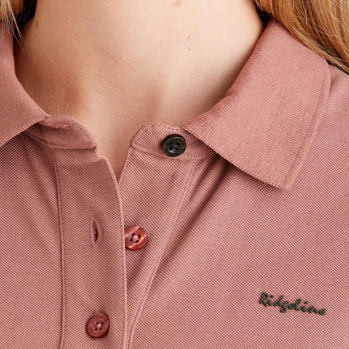 Close-up of a pink polo shirt with 'Ridgeline' branding.