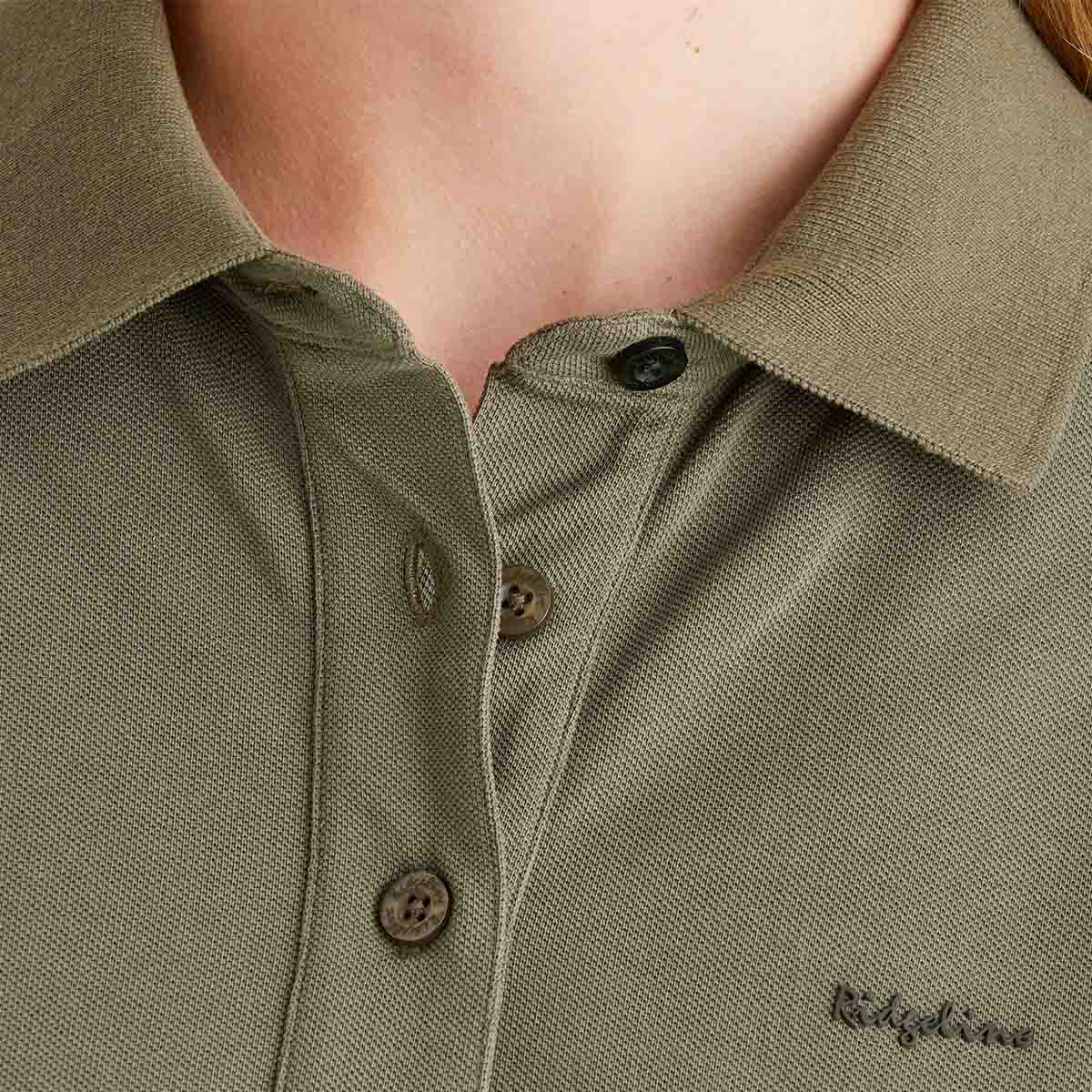 Close-up of a green polo shirt with buttons and 'Ridgeline' branding.