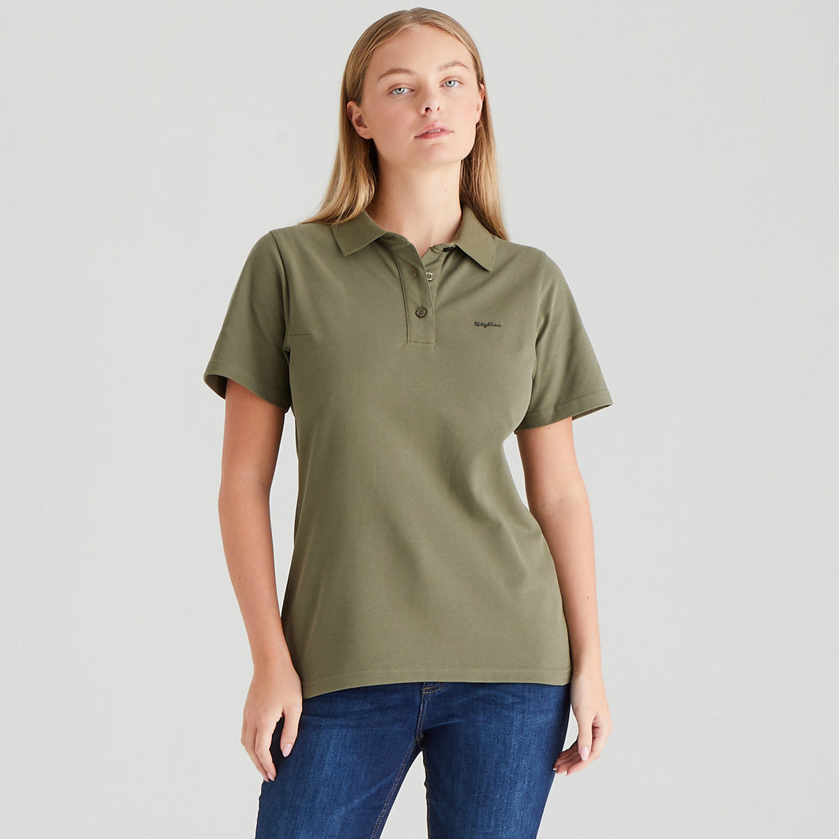 Woman wearing an olive green polo shirt on a gray background