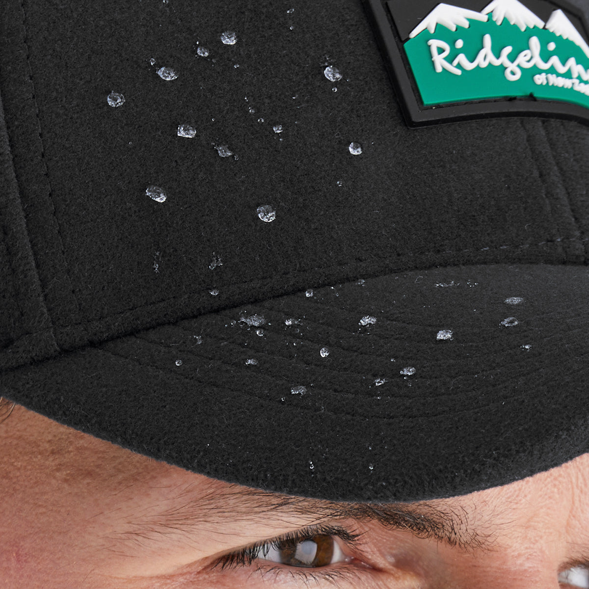 Black cap with water droplets and a visible brand logo
